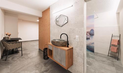 a bathroom with a sink in a room with a table at Apart Al-Aviöler in Ischgl