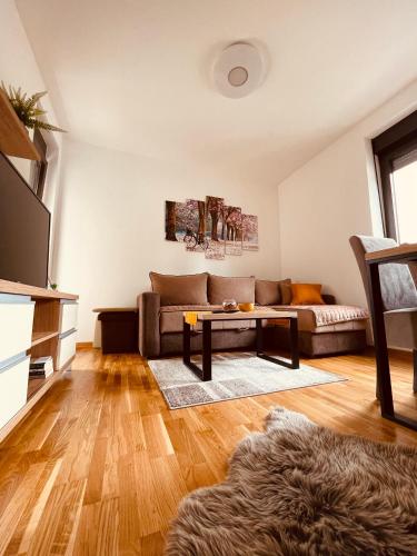 a living room with a couch and a table at Apartmani Vojinović in Zlatibor
