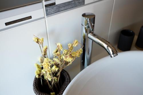 a bathroom sink with a vase with flowers in it at Countryside Villa with Nature & Pool - 'Casa dos Vasconcelos' in Chaves