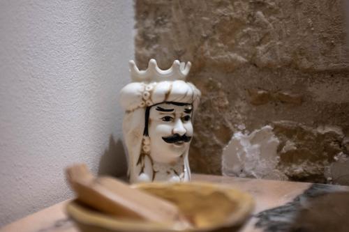 a statue of a head with a crown on a table at Cuturissi Hospitality & Wellness in Ragusa