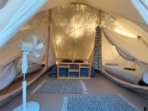 a tent with a fan and two rugs in it at Anthea Ecolodge Milina in Milína