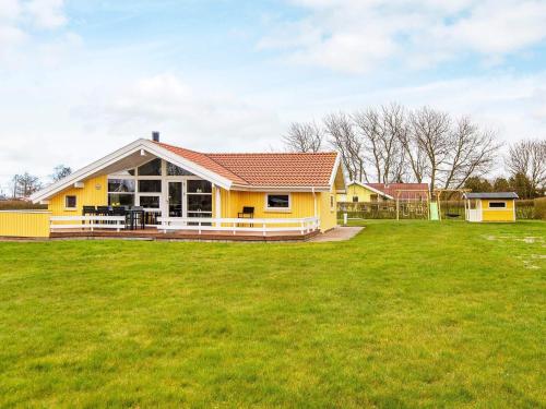 una casa amarilla con un gran patio verde en 6 person holiday home in Nordborg, en Nordborg