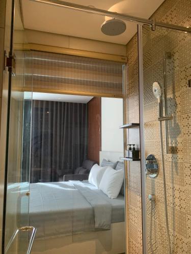 a bedroom with a bed and a glass shower at Win Condotel Apec Phú Yên in Tuy Hoa