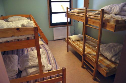 a room with three bunk beds and a mirror at Vimmerby Vandrarhem in Vimmerby