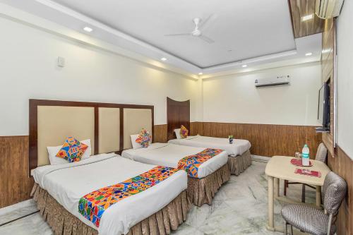 a hotel room with two beds and a table at FabHotel Jindal Palace in New Delhi