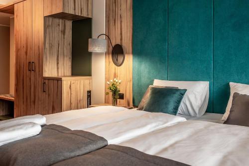 a bedroom with a large white bed with a green wall at OTTON-Charzykowy Bed&Restaurant in Chojnice