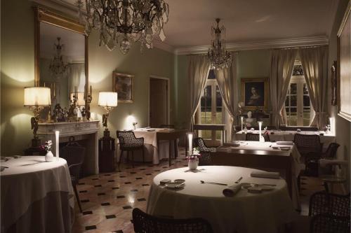 a dining room with two tables and a chandelier at Villa Abbondanzi Resort in Faenza