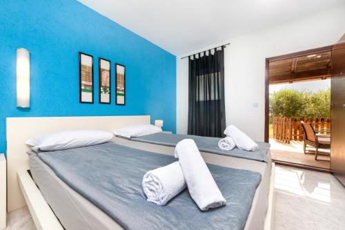 two beds in a bedroom with a blue wall at Secret Rooms in Rovinj