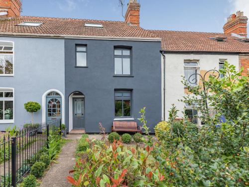 a blue house with a bench in a garden at 7 Severn Terrace in Watchet