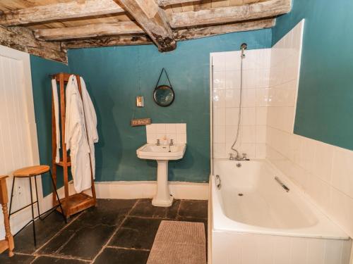 a bathroom with a tub and a sink and a bath tub at Yr Hen Dy in Colwyn Bay