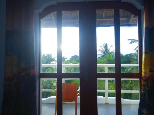 an open door with a chair in front of a window at MG Chateau Resort in El Nido