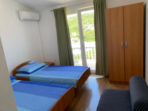 um quarto com 2 camas e uma porta de vidro deslizante em Room Ivana em Neum