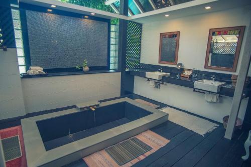 a large bathroom with a large tub and two sinks at Baan Suan Residence เฮือนพักบ้านสวน in Chiang Mai