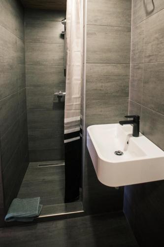 a bathroom with a sink and a shower at Goba Sauleskempings in Mērsrags