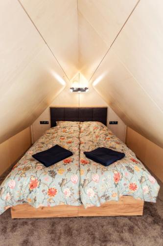 a small bedroom with a bed in the attic at Goba Sauleskempings in Mērsrags