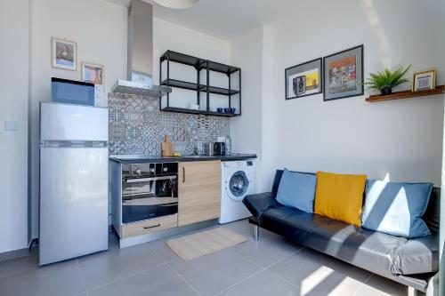 a kitchen with a refrigerator and a couch in a room at Sliema Creek Suites in Sliema