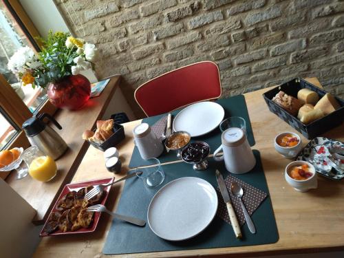 stół z talerzami i naczyniami na górze w obiekcie chambres d'hôtes Le Carillon w mieście Bergues