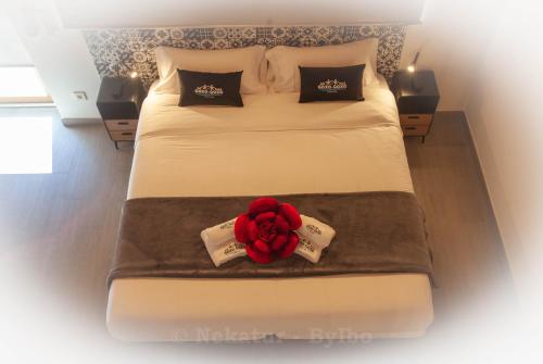 een slaapkamer met een bed met een rode roos erop bij Goxo-Goxo in Régil