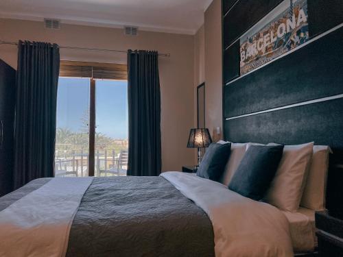 a bedroom with a large bed and a large window at IL-Gardjola Bed and Breakfast in Għarb