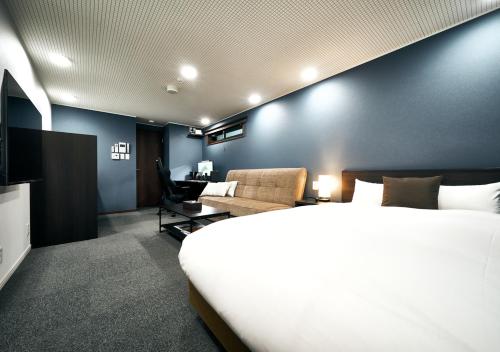 una camera d'albergo con un grande letto e un divano di Villa Front Kyoto Seimei a Kyoto