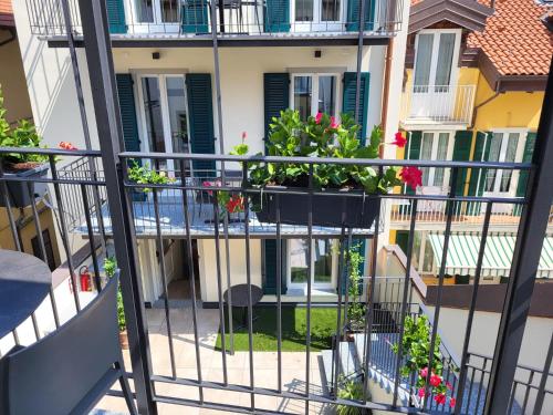an apartment balcony with flowerpots on a building at Sempione Boutique Hotel in Stresa