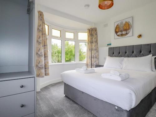 a bedroom with a large bed and a window at Pen-Y-Thon House in Newquay