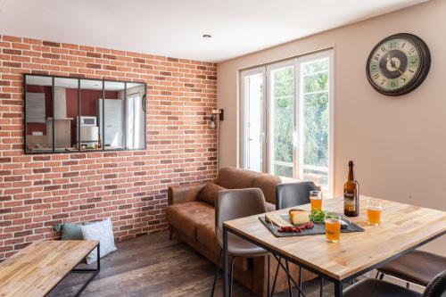 uma sala de estar com uma mesa e um sofá em NOUVEAU - T2 Industriel - Quartier historique - WiFi - Parking - Netflix em Hennebont