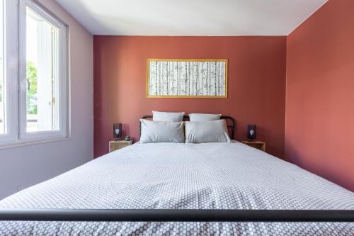 um quarto com paredes vermelhas e uma cama branca em NOUVEAU - T2 Industriel - Quartier historique - WiFi - Parking - Netflix em Hennebont
