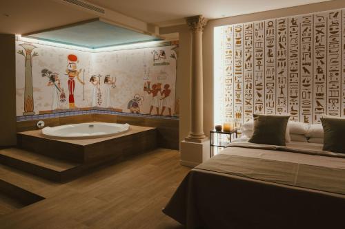 a bathroom with a bath tub next to a bed at Valle del Nilo in Ventas de Poyo