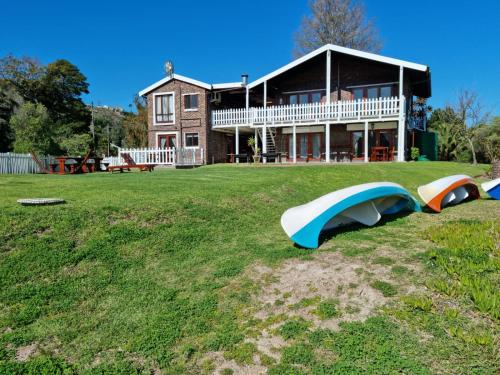a house with three slides on the lawn in front of it at Salt River Lodge in Knysna
