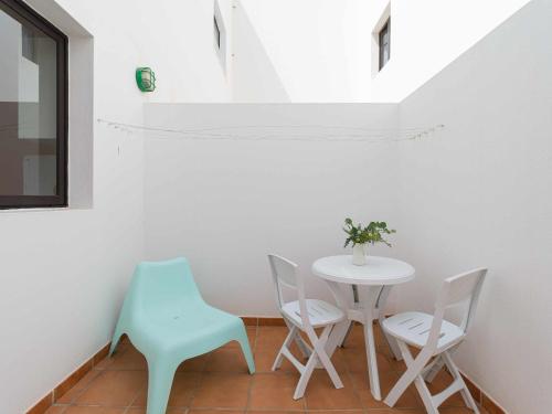 una pequeña mesa y sillas en una habitación con ventana en Mahostly Apartamento Comillas PG, en Arrecife