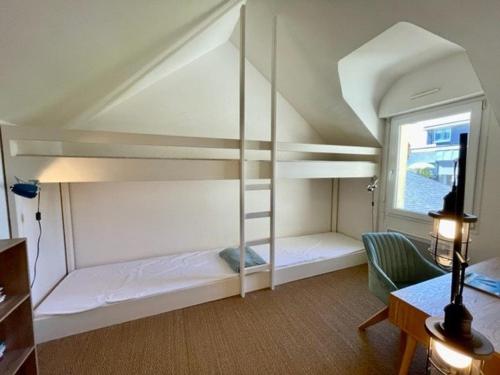 Cette chambre comprend 2 lits superposés et une fenêtre. dans l'établissement Maison atypique 5 pièces 160m², centre Quiberon, proche plage et commerces - FR-1-478-227, à Quiberon