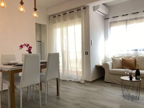 sala de estar con mesa, sillas y sofá en Coqueto apartamento de Playa con Piscina y Terraza, en Valencia