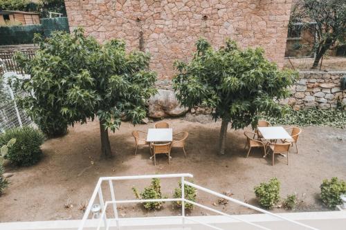 un patio con mesas, sillas y árboles en Résidence Idéal-Subrini, en Porto Ota