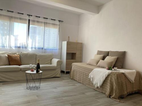 sala de estar con cama y sofá en Coqueto apartamento de Playa con Piscina y Terraza, en Valencia