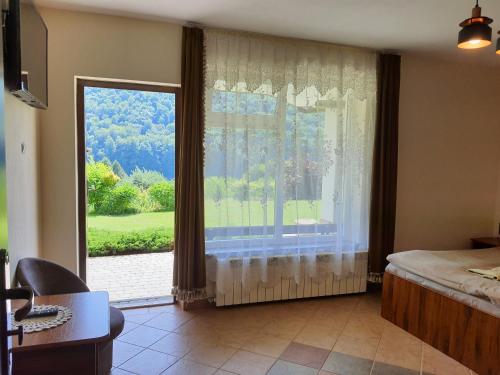 a bedroom with a large window with a view at Noclegi Nad Jeziorem Myczkowieckim in Solina