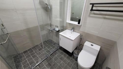a bathroom with a toilet and a sink and a shower at Maple Leave Holiday Villa in Renai