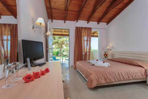 a bedroom with a bed with red roses on a table at Aegean View Aqua Resort in Psalidi