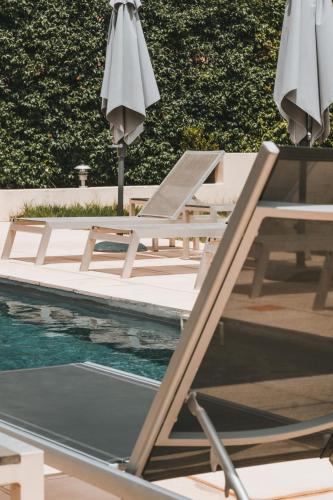 - un groupe de chaises longues et de parasols à côté de la piscine dans l'établissement Résidence Idéal-Subrini, à Porto Ota
