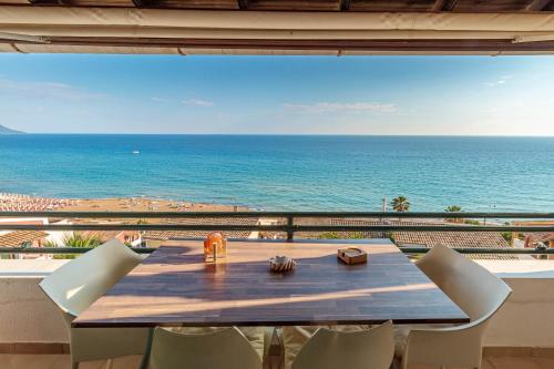 a table with chairs and a view of the ocean at Glyfada Home 113 by New Era in Menigos Resort Apartments in Glyfada