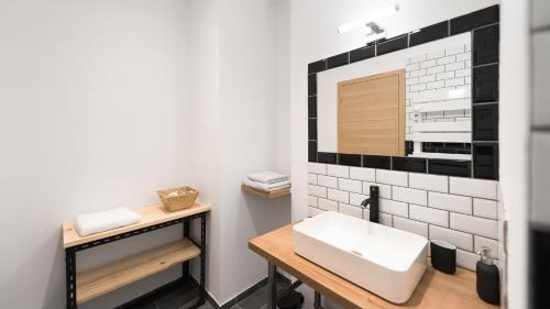 łazienka z umywalką i lustrem w obiekcie L'Atelier Flanelle w mieście Le Mans