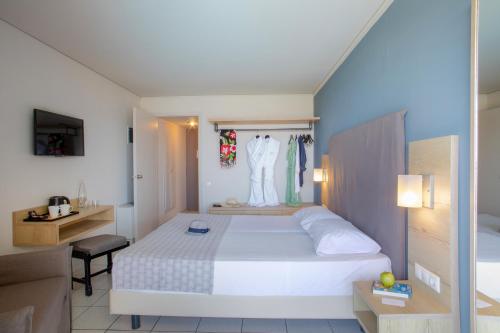 a bedroom with a large white bed and a desk at Sol Marina Beach Crete in Gouves