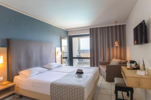 a hotel room with a bed and a living room at Sol Marina Beach Crete in Gouves