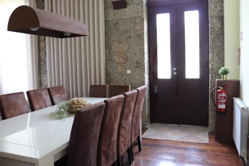 a dining room with a white table and brown chairs at Quinta da Presa in Vermoim
