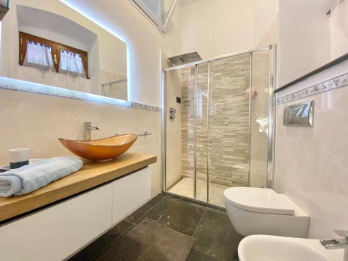a bathroom with a wooden bowl sink and a shower at CasaViva - Trilo on the heights of S Margherita in San Lorenzo della Costa