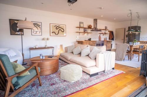 a living room with a couch and a table at Penthouse at The Old Tea Factory in London