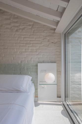 a bedroom with a white bed and a window at Scaravelli Residenza in Mantova