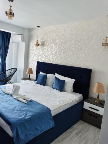 a bedroom with a blue and white bed with blue sheets at Ren Litoral in Năvodari