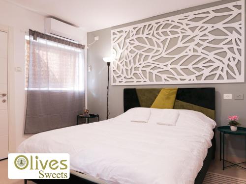 a bedroom with a large white bed and a window at Olives sweets in Arad