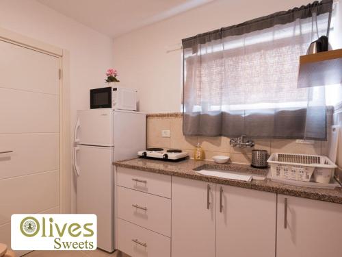 a kitchen with a white refrigerator and a window at Olives sweets in Arad